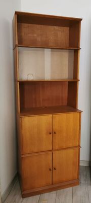 a wooden bookcase with two drawers in the corner of the room