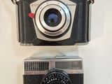 two cameras on a table with a strap around them