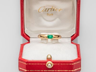 une bague en or sertie d'une pierre verte, dans un coffret rouge