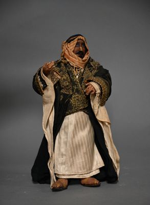 statue d'un homme vêtu d'une tenue noire et dorée