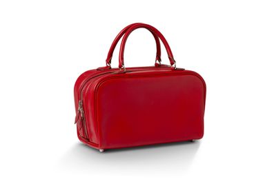 un sac à main rouge posé sur une surface blanche