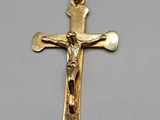 a close up of a cross on a gold chain on a table