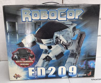 toy box of a robot with a gun in it on a white surface