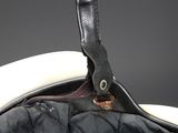 the inside of a black and white purse with a leather handle