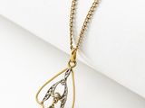a gold and silver necklace with a tear shaped pendant on a chain