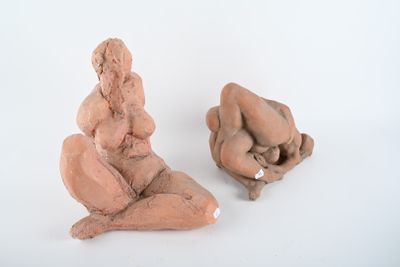 deux sculptures en argile représentant une femme et un homme, posées sur une surface blanche