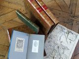 three books sitting on a wooden floor next to each other