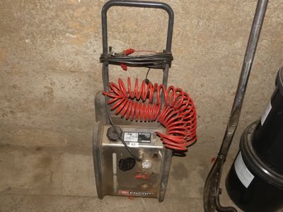 une photo d'un compresseur d'air portable dans un sous-sol