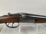 an old gun with a wooden handle on display in a clear case