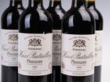 four bottles of wine are lined up on a white surface