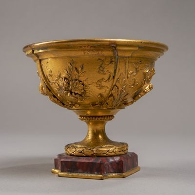un vase en or posé sur un socle en marbre