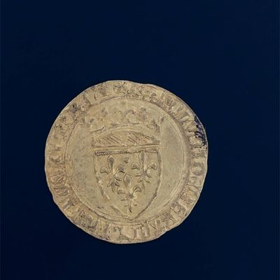 a close up of a gold coin on a black surface