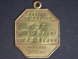 a gold medal on a black surface with a name on it