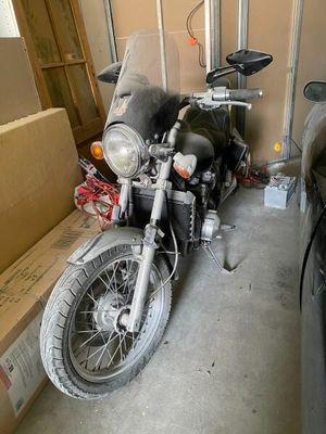 a motorcycle that is parked in a garage next to a car