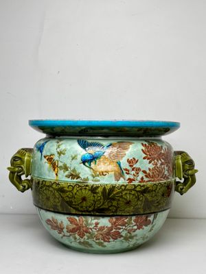 un vase bleu et vert orné d'un motif représentant un oiseau