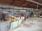 Plusieurs morceaux de bois sont empilés dans un abri