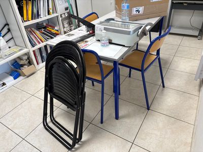 a table with chairs and a laptop on it in a room