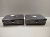 two black boxes sitting on top of a white table