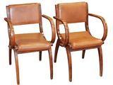 deux fauteuils en cuir marron avec des accoudoirs en bois