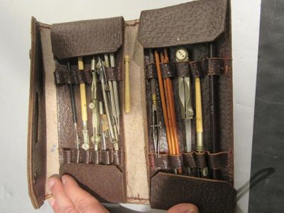 a person holding a leather case with a bunch of tools inside of it