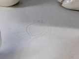 a white vase with a drawing on it next to a computer mouse