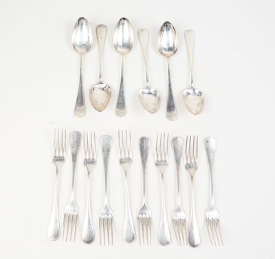 a lot of silver spoons and forks laid out on a table