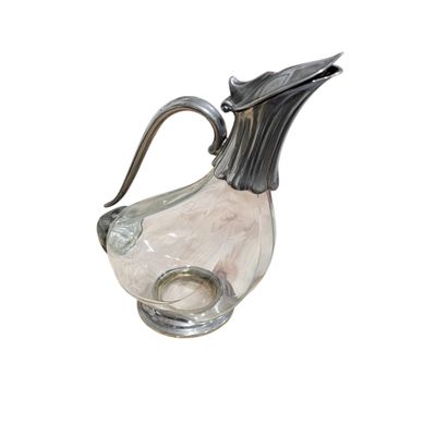 a glass pitcher with a metal handle on a white background