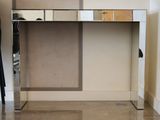 un miroir fixé sur le côté d'un bureau muni d'un porte-manteau