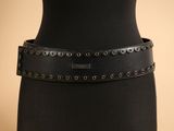 un gros plan sur la ceinture d'une femme ornée de rivets