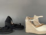 pair of black and white wedged shoes on a gray surface