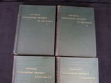 four books are sitting on a black cloth covered surface