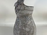 a gray vase with a butterfly on it