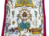 un gros plan sur un foulard carré sur lequel sont disposés divers objets