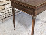 a wooden table with a glass top sitting on a cement floor
