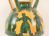 a green and yellow vase with a picture of a man and a woman on it