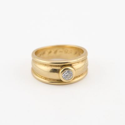 gros plan d'une bague en or avec un diamant au centre
