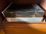 a record player sitting on top of a wooden cabinet