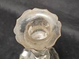 a clear glass candle holder on a black surface