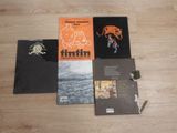 three books are sitting on a wooden floor next to each other