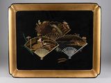 an image of a black and gold plate with a fan on it