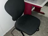 une chaise de bureau noire posée à côté d'un bureau blanc