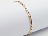 un bracelet en or posé sur une serviette, sur une surface blanche