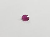 a pink sapphire stone on a white surface