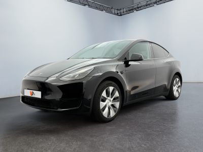 La Tesla Model Y noire est garée dans une pièce blanche