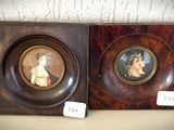 deux portraits encadrés représentant un homme et une femme, posés sur une table