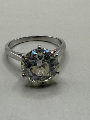 a close up of a diamond ring on a white surface