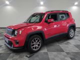 Une jeep rouge est garée sur un sol à damier dans un garage.