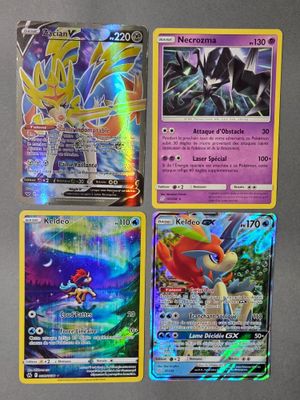 Quatre cartes Pokémon différentes sont représentées sur une surface grise.