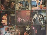 a lot of rolling stones album covers on the wall