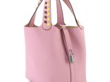 a pink handbag with studded handles on a white background